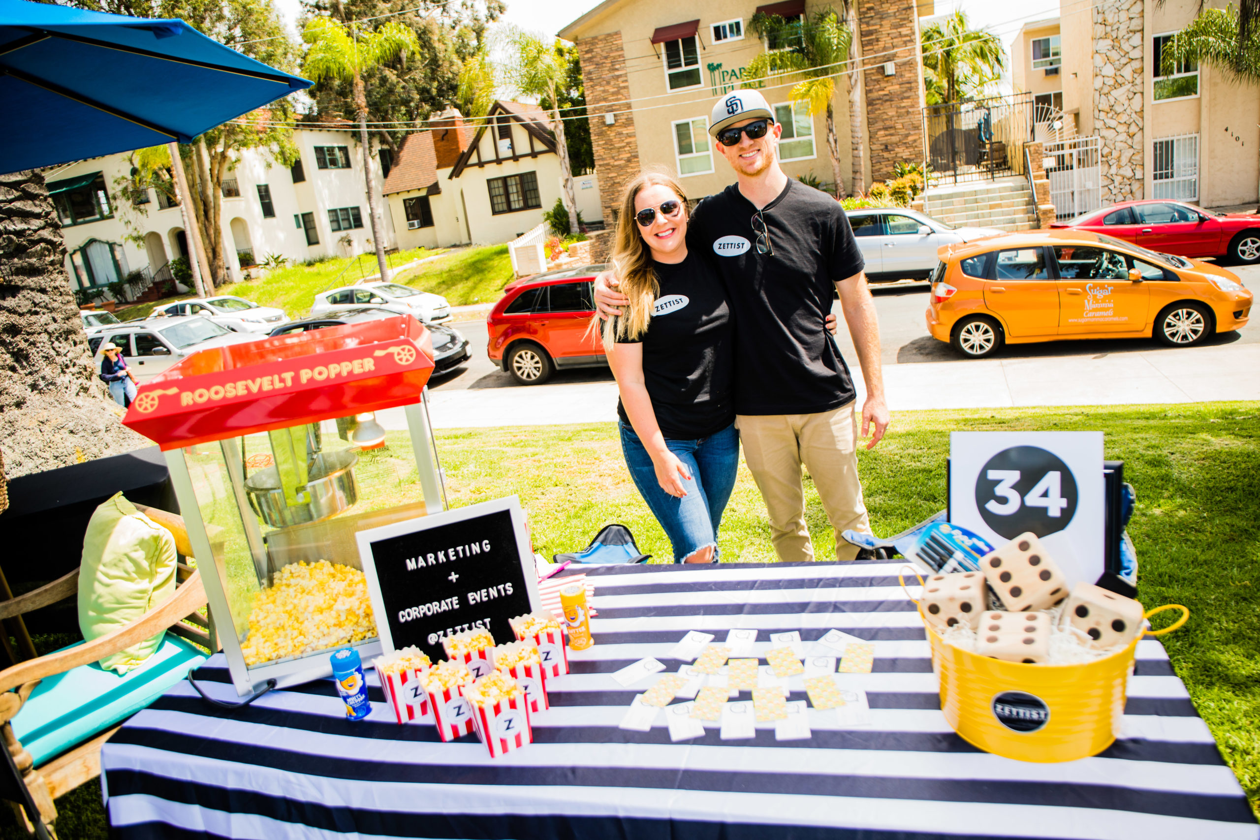 Jana Devan, Founder of Zettist, and husband at a community event in San Diego giving away popcorn at an information booth